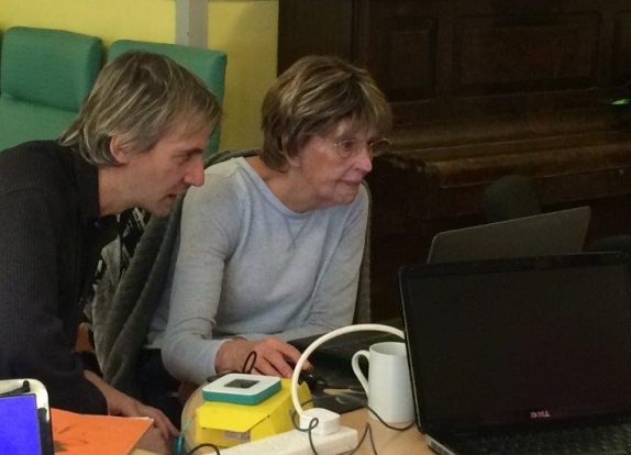 two people looking intently at computer screen