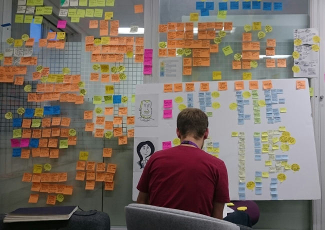 researcher facing wall of Post-it notes