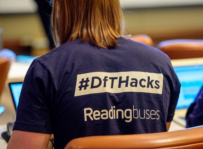 back of a person wearing a DfT Hacks branded t-shirt