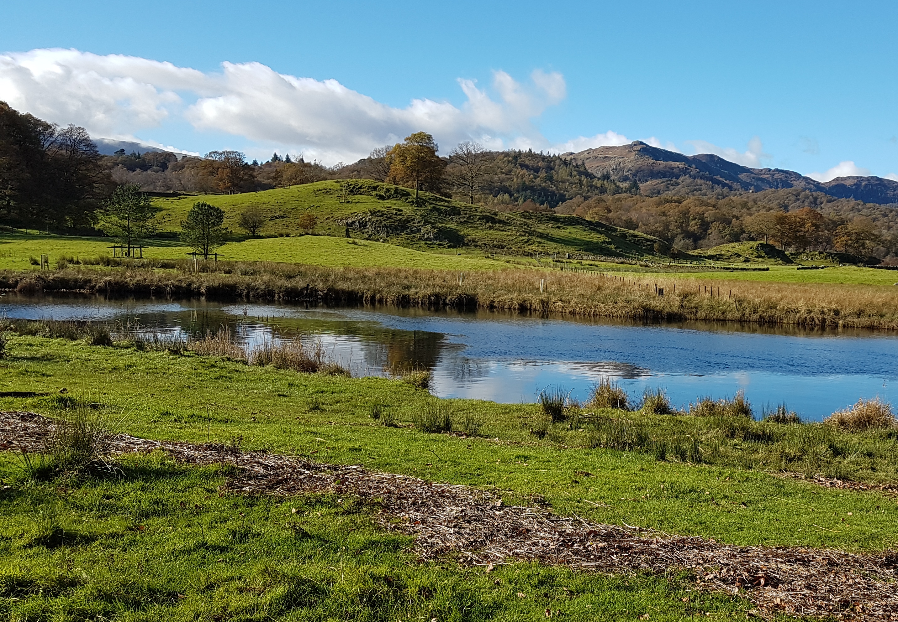 a body of water with hills in background