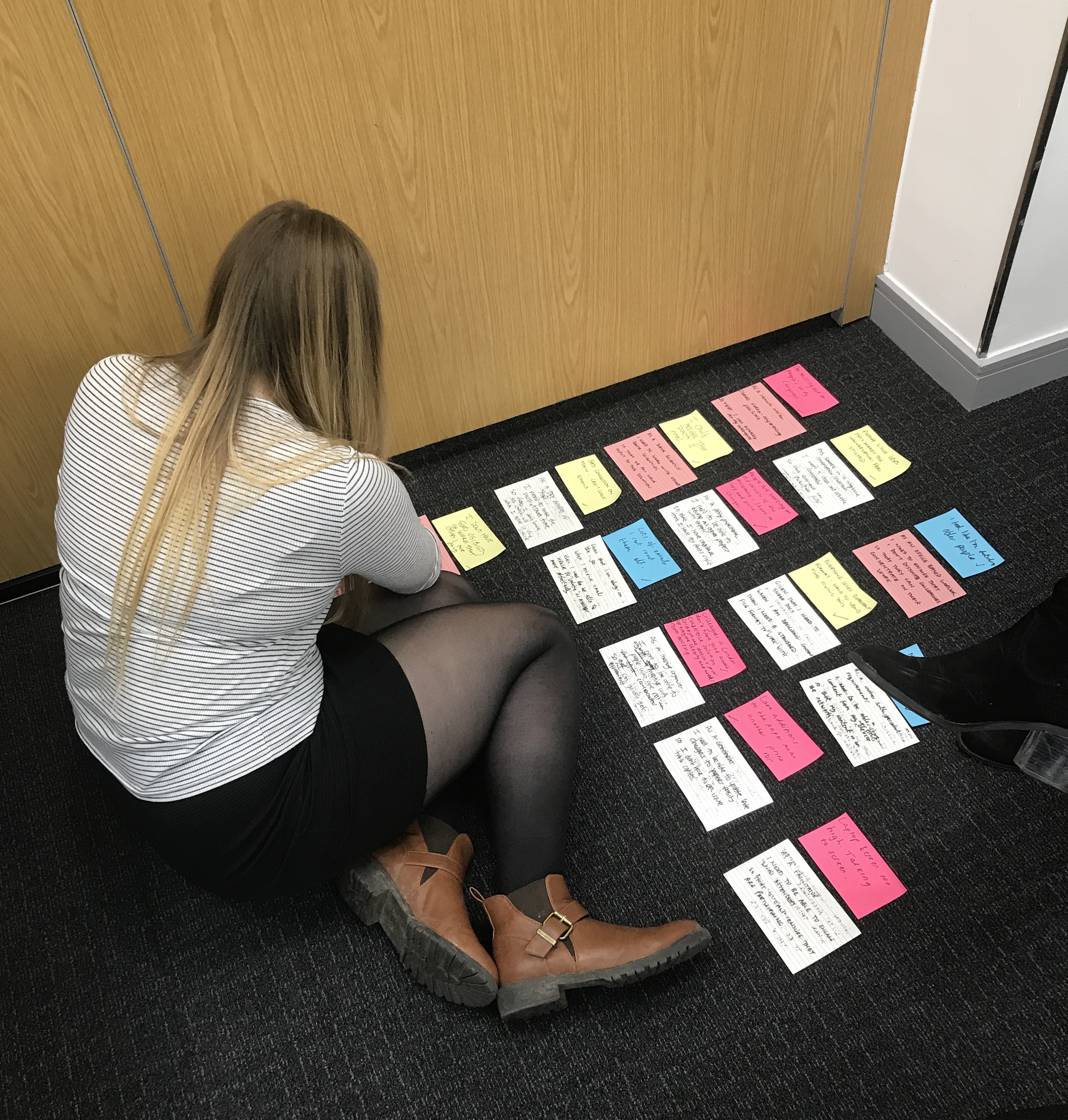 Gemma doing a card sort on a corner of the office floor