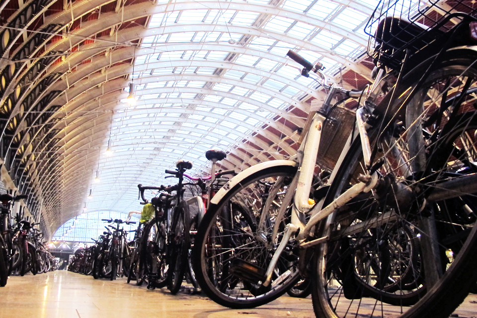 closeup view of many bikes parked under a large glass roof